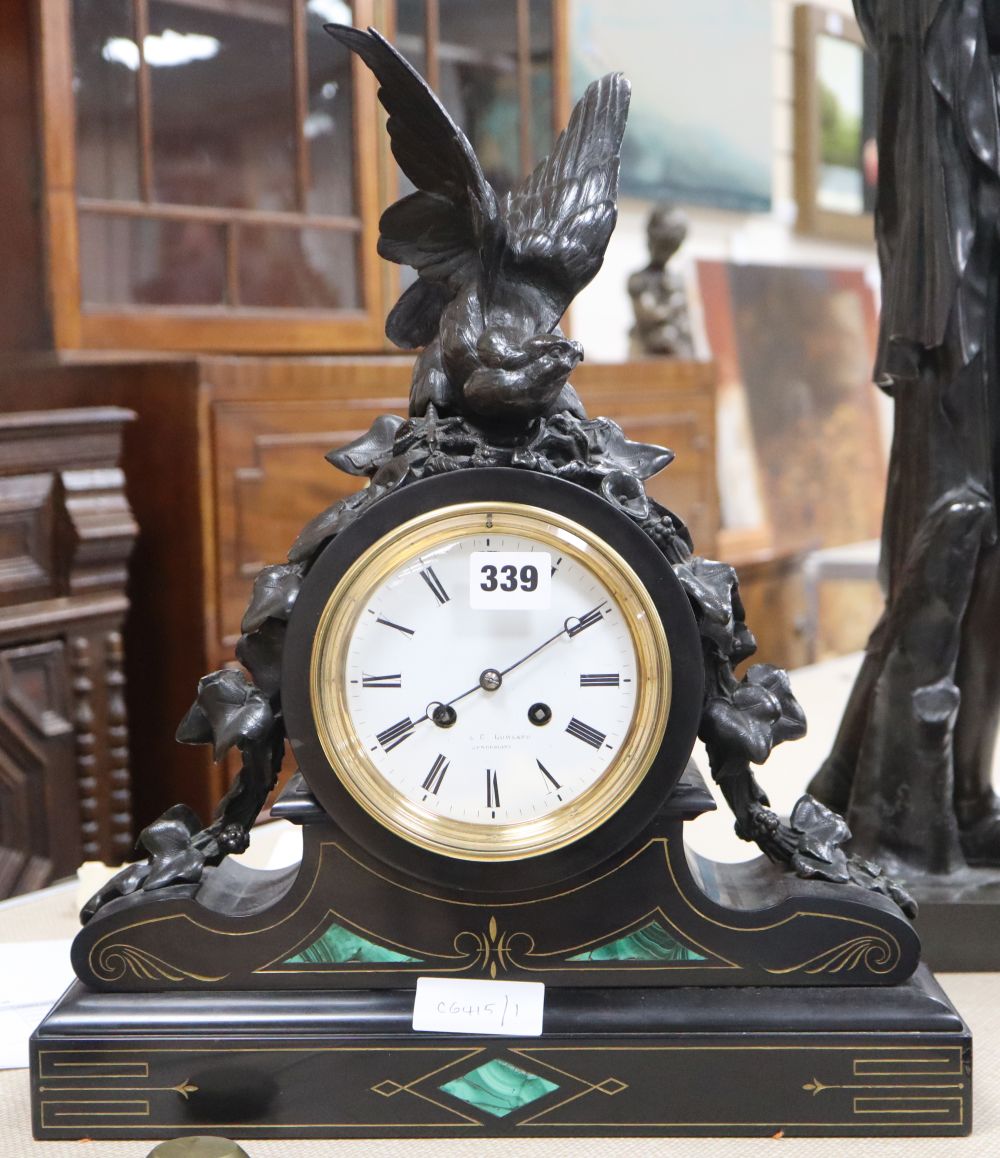 A Victorian malachite black slate mantel clock, with spelter bird surmount